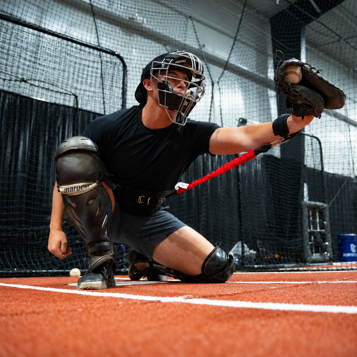 Close-up of the Real Feel Catching Resistance Trainer belt, resistance band and wrist cuff being used with a catcher's mitt.